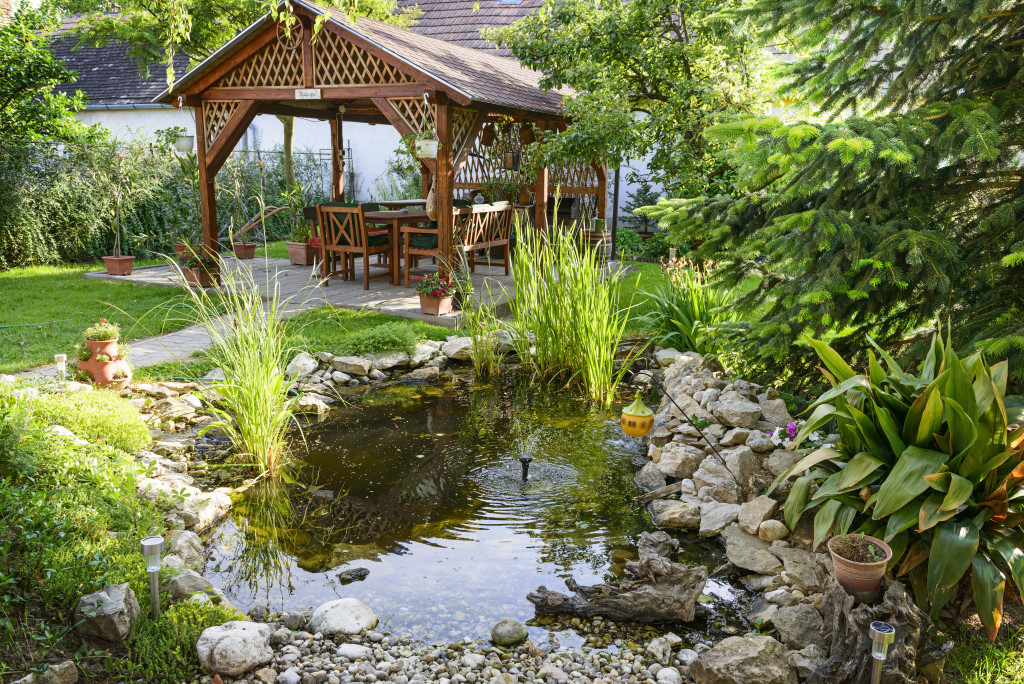 A beautiful garden with a covered living space and a pond