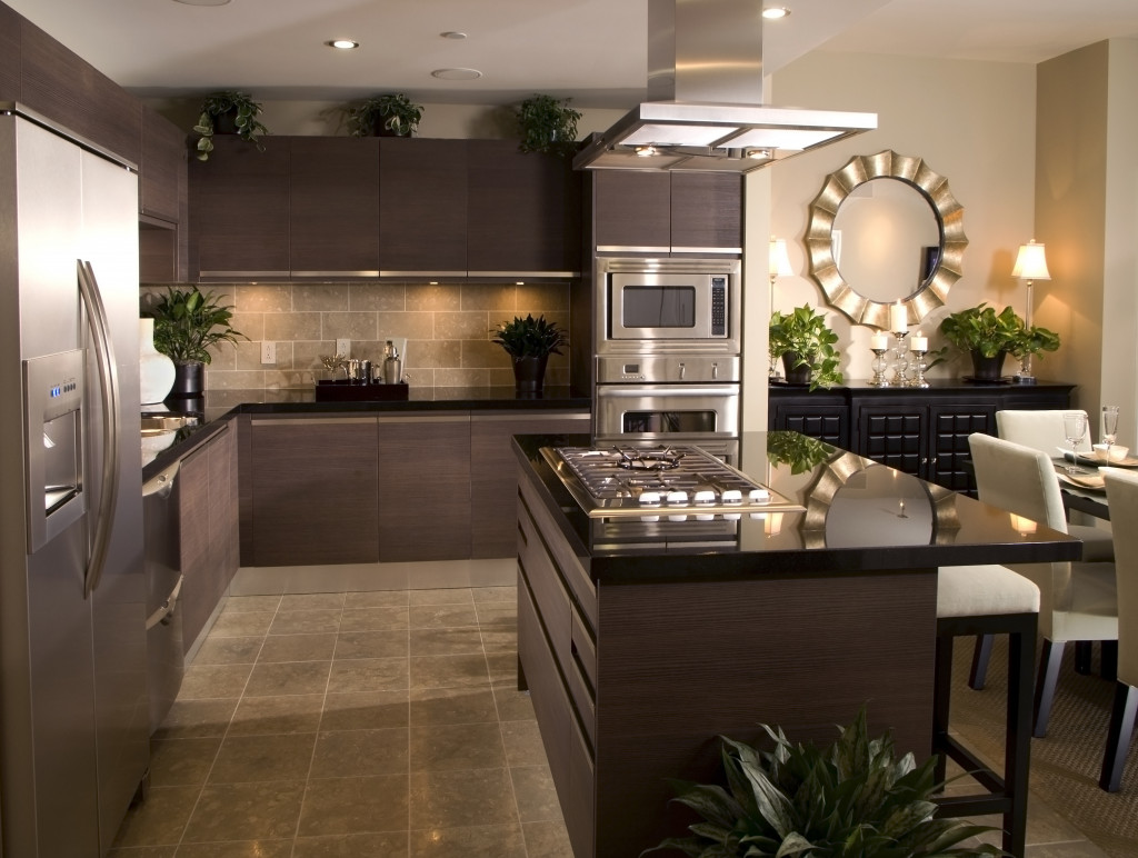 Interior design of a modern kitchen with a refrigerator, kitchen counter, oven, sink, dining table, and chairs.