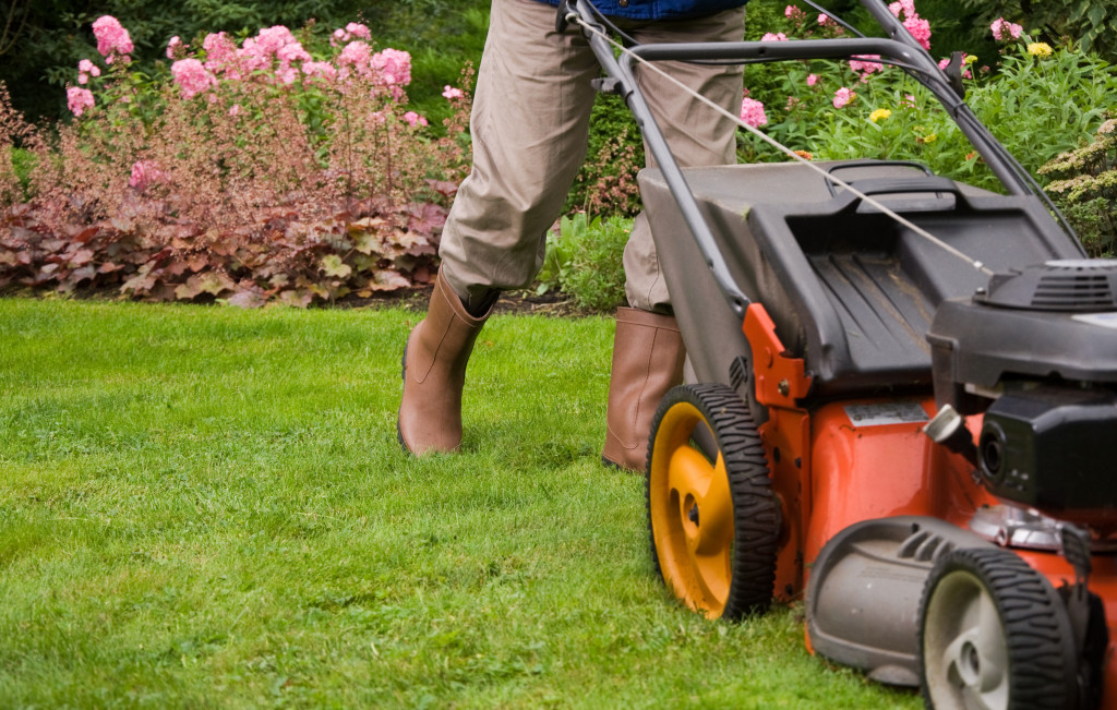 gardener mowing the lawn of home or property 