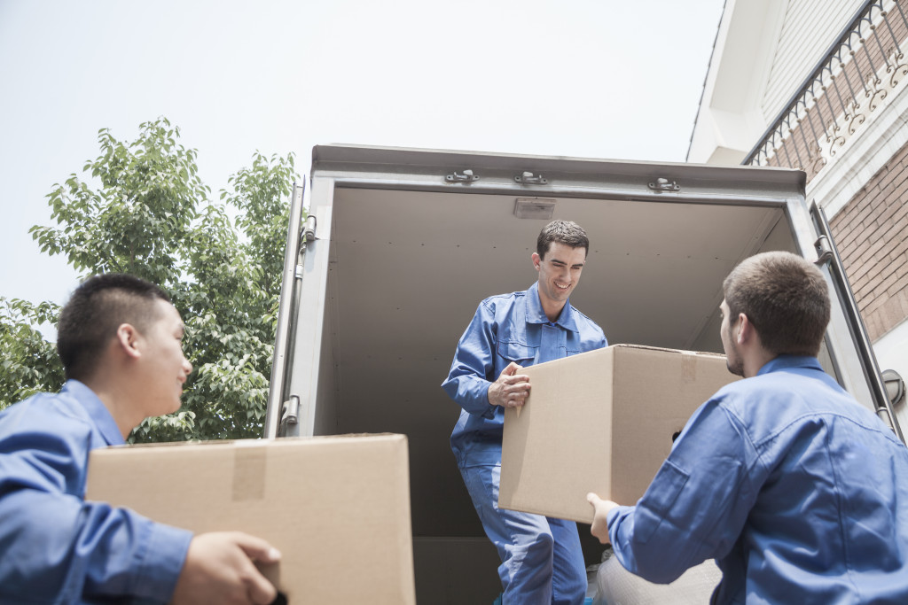 Three movers unloading boxers from a truck