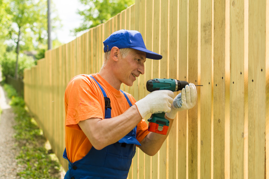 worker installing wood fence