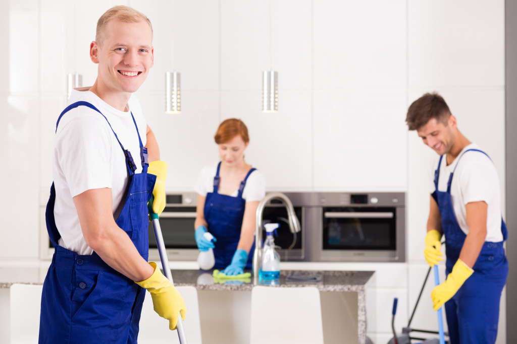 Professional home cleaners working at a kitchen.