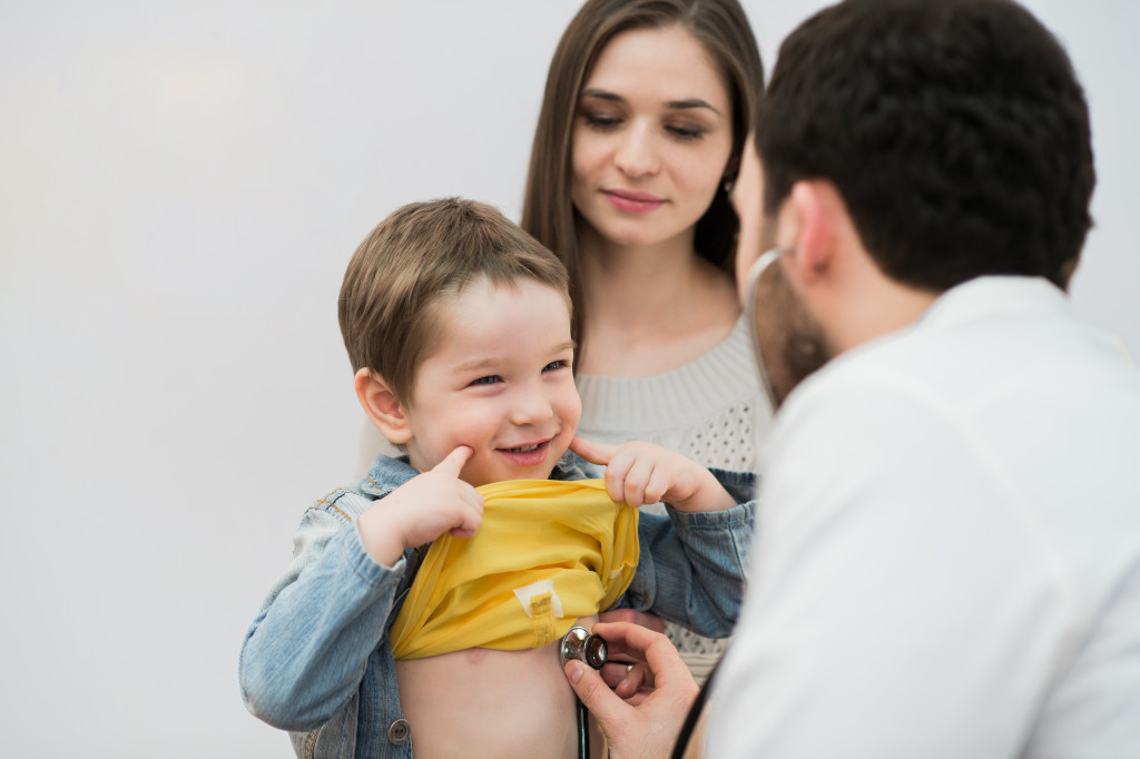 a doctor checking a little boys heartbeat