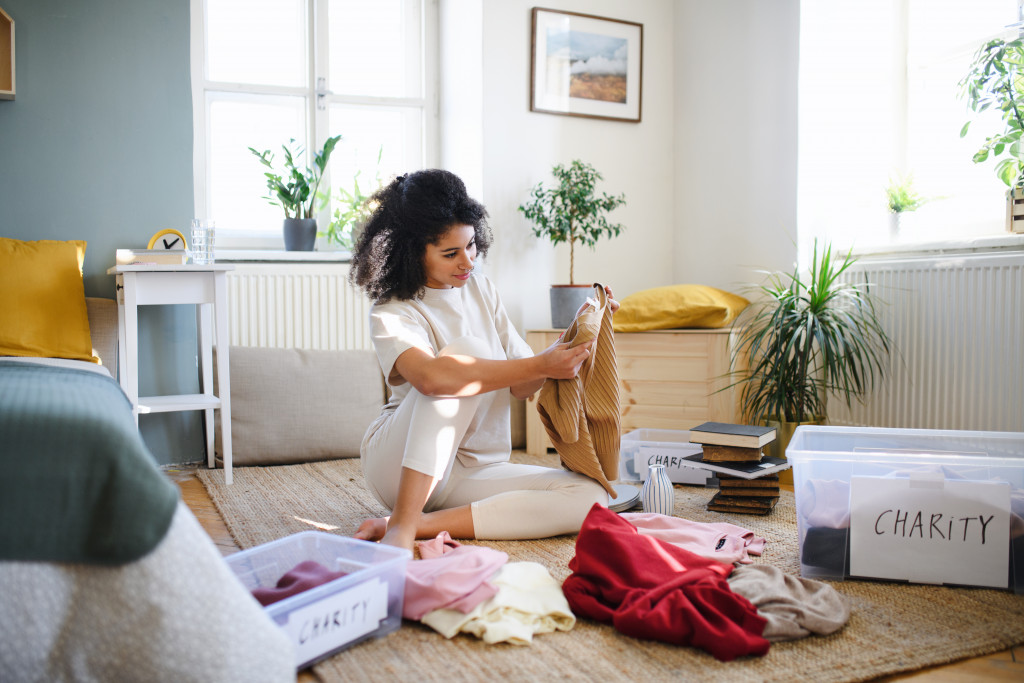 Young woman sorting her wardrobe at home.